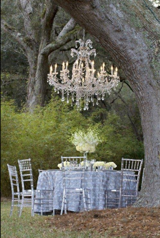 charming outdoor tablescape under a tree with a crystal chandelier