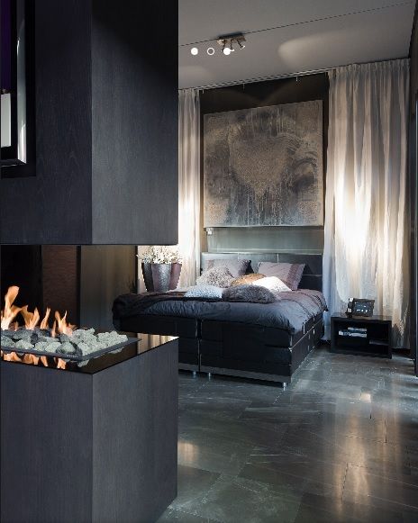 luxurious master bedroom with three sided linear gas fireplace, polished concrete floor, and large abstract artwork