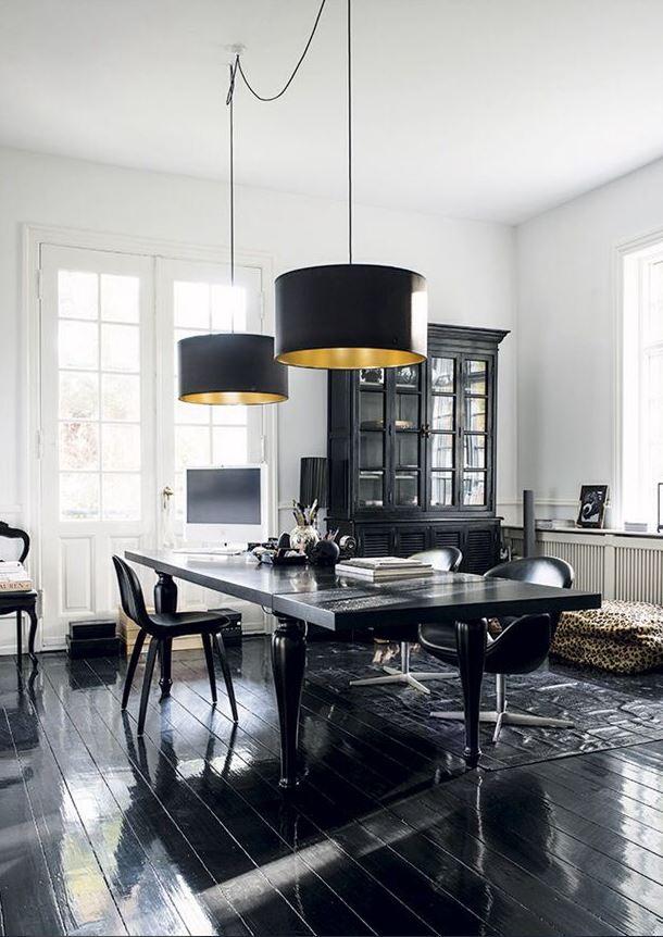 black and white dining room with black furniture, flooring, and paired drum pendant lighting, and white walls
