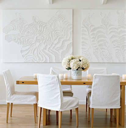 charming casual white dining room with paired white artworks and slip covered dining chairs