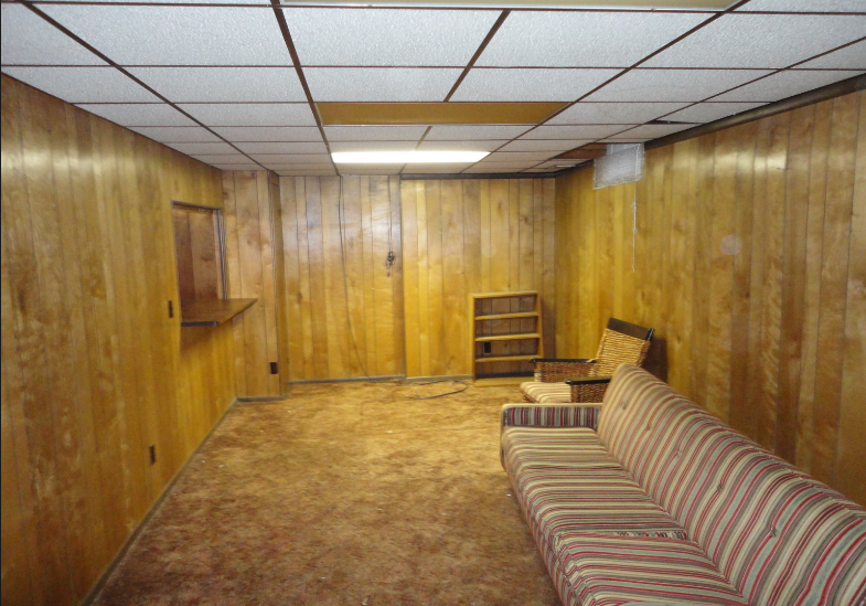 dated 1960's basement rec room with sad wood panelling