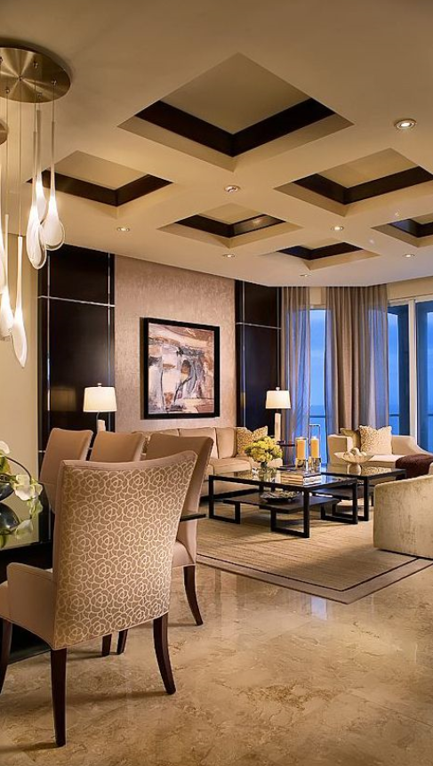 sleek and upscale adjacent living and dining room with coffered ceiling