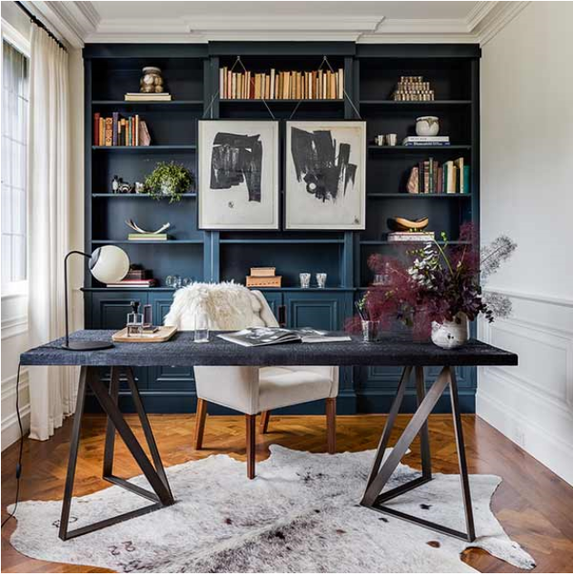 elegant home office with deep blue cabinetry storage and cow hide area rug