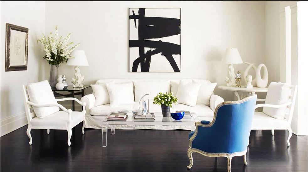 upscale traditional formal white living room with one blue chair and contemporary black and white abstract artwork