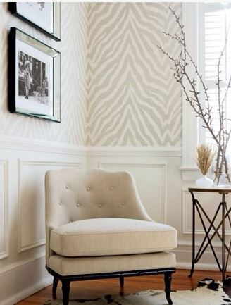 zebra print wallpaper with tufted armless chair and mirror edged artwork