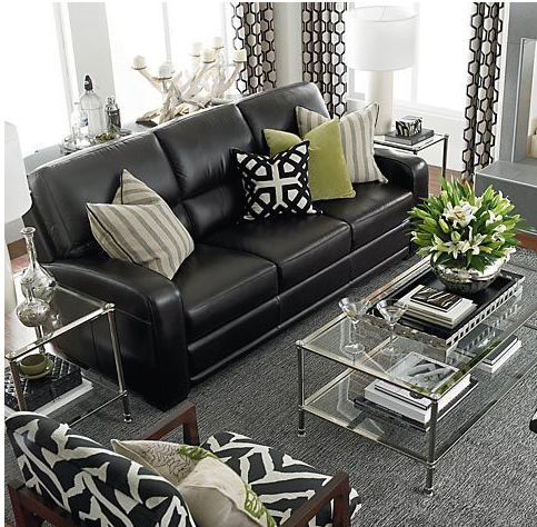 small contemporary living room in neutral colour palette with black clean lined sofa, grey area carpet, and custom draperies and toss cushions in geometric motif