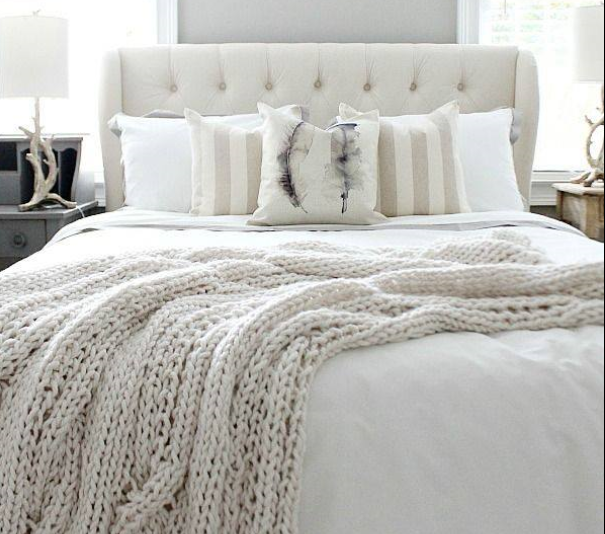 wide view of light and fresh master bedroom with white bedding and white knitted throw