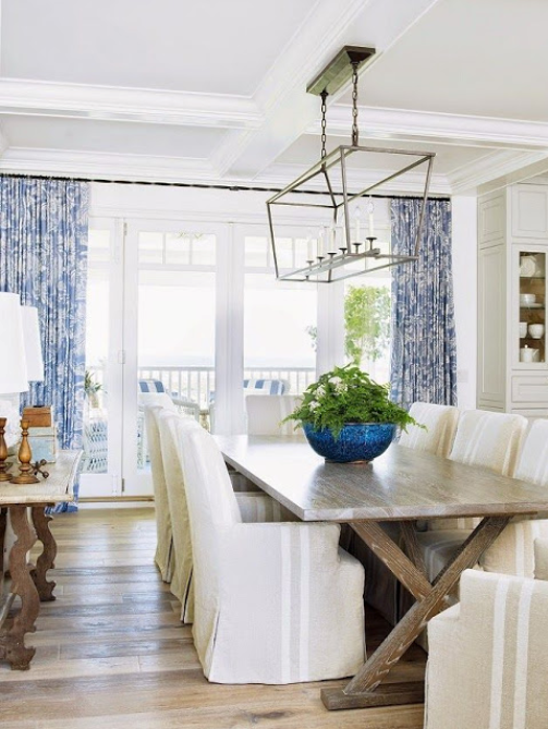 coastal style dining room with weathered table and custom draperies in blue