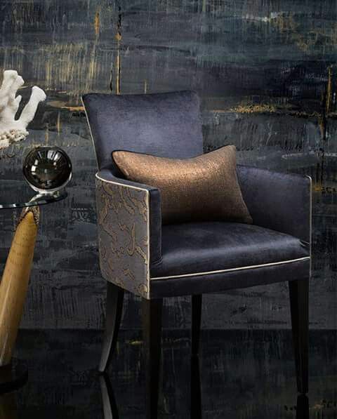 elegant and dramatic room vignette with deep blue abstract wall finish and upscale club chair with gold toss cushion