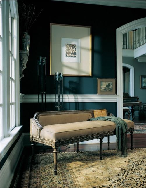 formal sitting area in dramatic traditional living room with antique bench, Oriental carpet, and deep teal wall colour