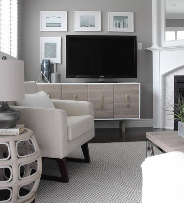 charming small living room with off centre flat screen television with art wall around television and subtle geometric motif area rug