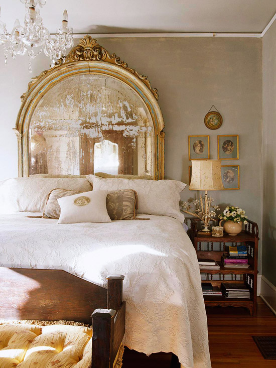 informal traditional bedroom with ornate arch top large mirror and distressed night table