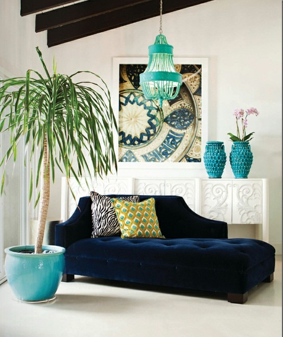 dramatic living room with navy chaise, white sideboard, and turquoise planter with tall plant