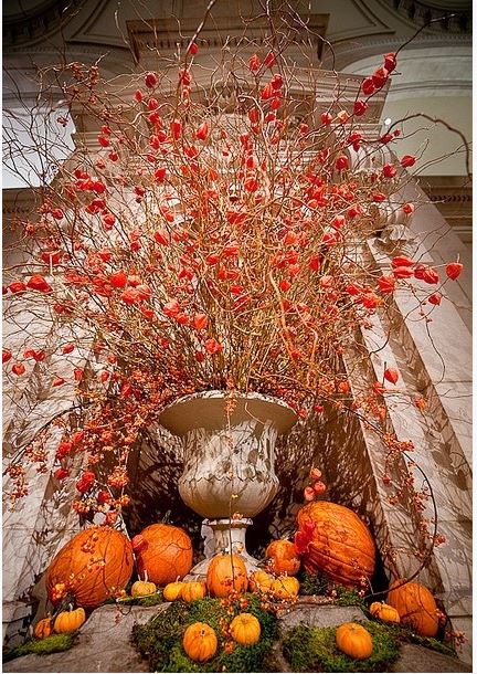 fall decor with classical urn with tall arrangement of curly willow, Chinese lanterns, and pumpkins and moss around the base