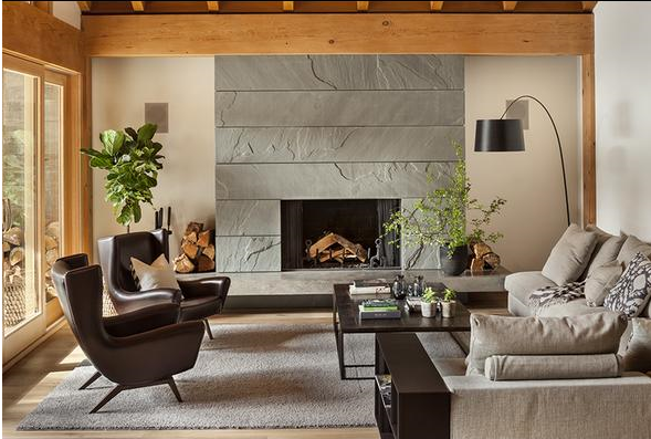 upscale casual family room with slate clad fireplace, paired leather egg chairs, and neutral colour palette