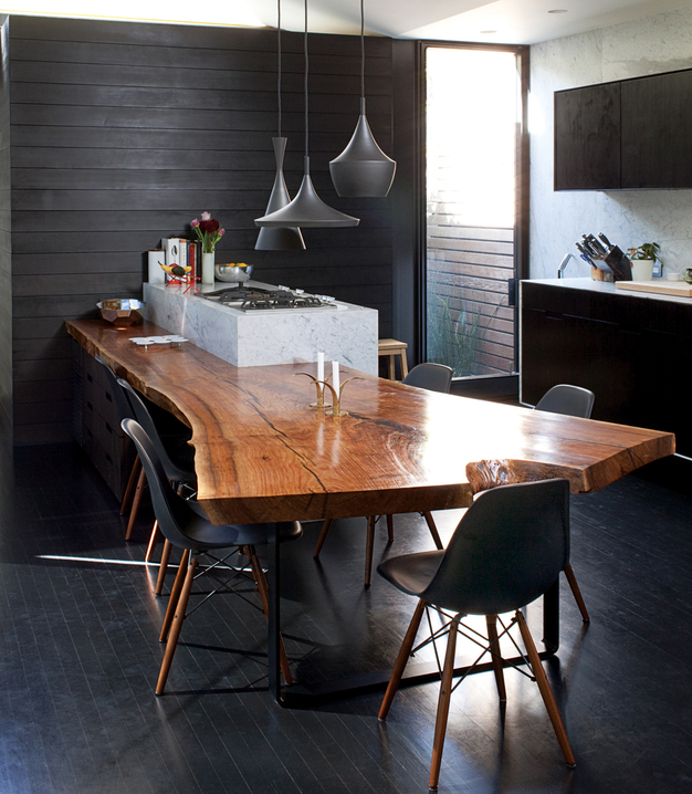 upscale dramatic kitchen with black cabinetry and live edge dining table