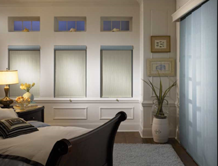transitional style bedroom with both panel track window blind and roller shade in screen fabric