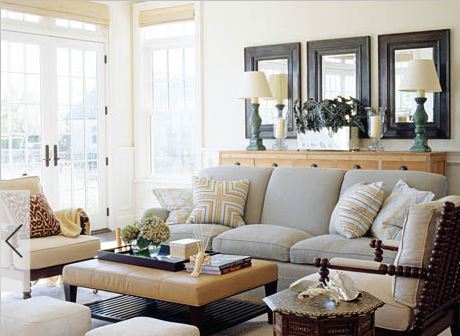 comfortable living room with muted colour palette, tan silk blinds, row of mirrors, and transitional sofa
