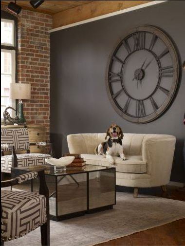 cute and happy beagle on cream sofa with paired geometric chairs, mirrored coffee table and large uttermost wall clock on deep charcoal wallcolour