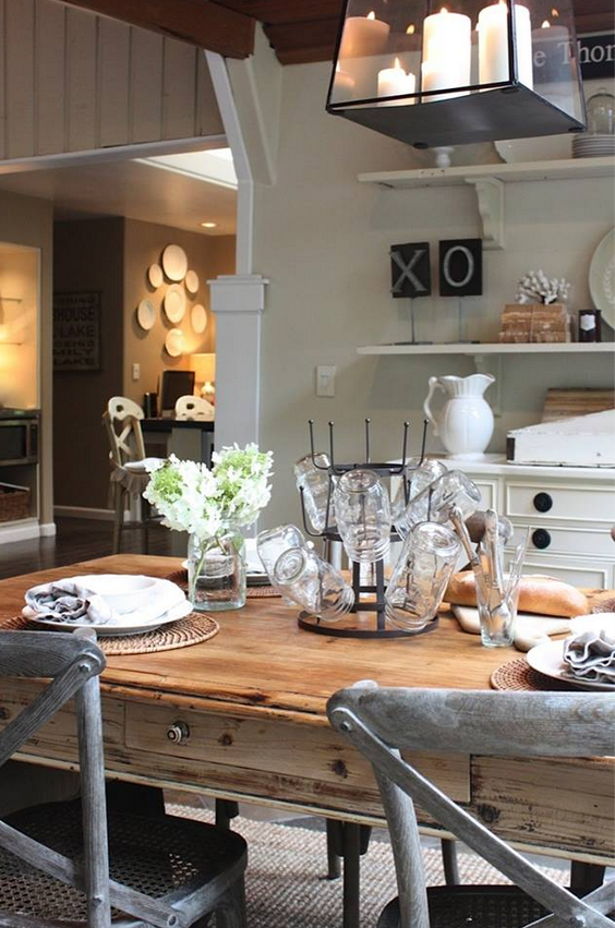 farmhouse stle kitchen with modern white cabinets and weathered harvest table and x back chairs