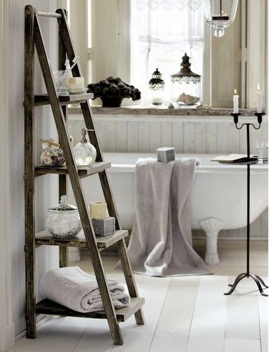 upscale rustic farmhouse chic bathroom with clawfoot tub, ladder accessory shelf, lantern chandelier, and wainscotting