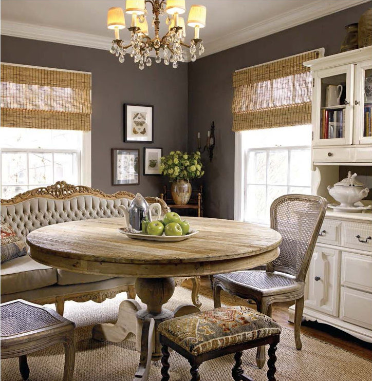 urban rustic farmhouse style dining room with reclaimed wood table, cane chairs, tufted French sofa and grass window blinds