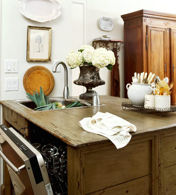 charming farmhouse kitchen with rustic cabinetry, tall pine armoire, and dishwaher