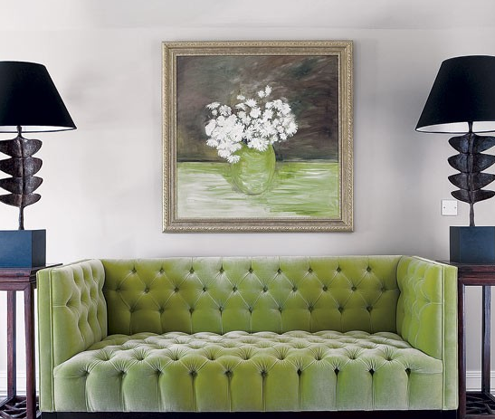 dramatic and beautiful living room with lime green velvet tufted sofa and paired black lamps